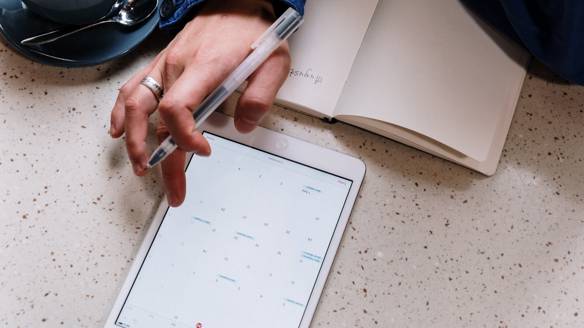 Person Holding Pen and Using a Tablet